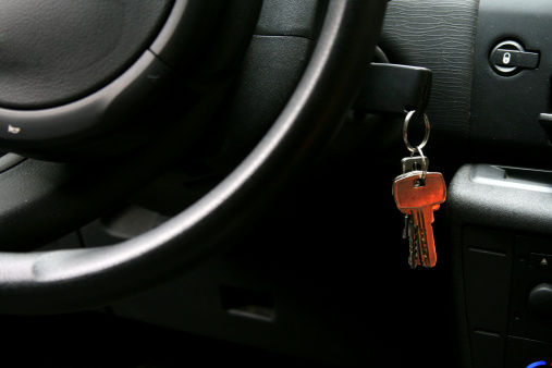 Key with metallic keychain on light grey background, top view