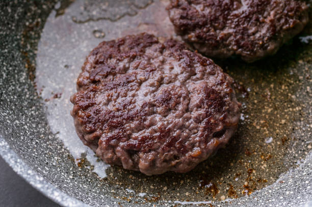 istock Close-up two appetizing juicy burger on a ceramic pan. 1182379568