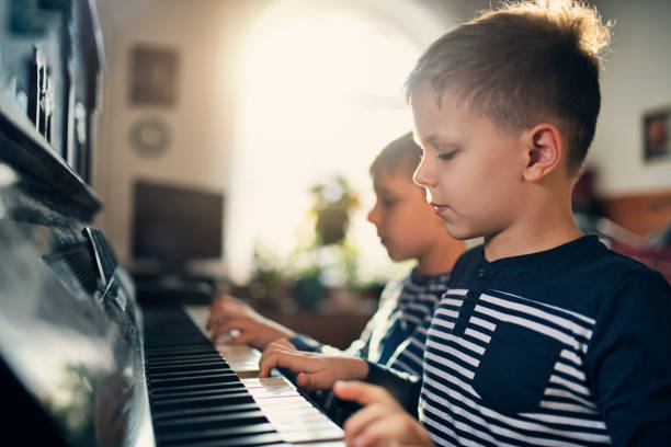 istock Twin brothers having fun practicing piano together 1182379936