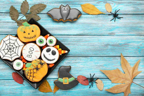 istock Halloween gingerbread cookies with dry maple leafs on blue wooden table 1182381429