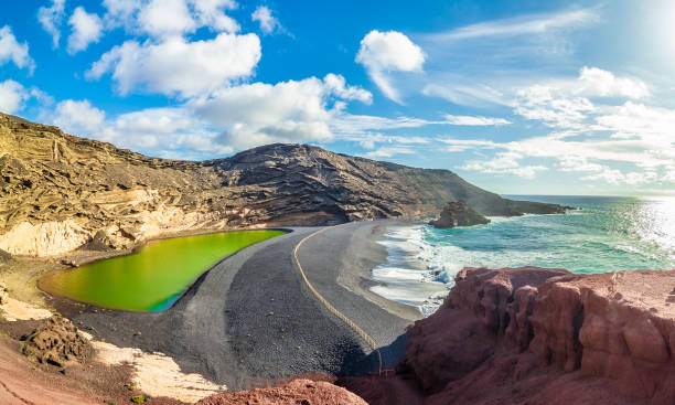 paisaje con únicas arenas negras y lago verde en la playa de el golfo - isla de lanzarote fotografías e imágenes de stock