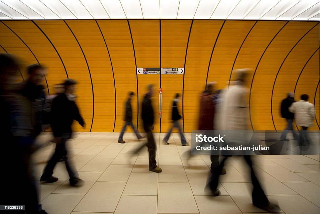 Gente en movimiento borroso en contra de un túnel de naranja moder - Foto de stock de Andén de estación de metro libre de derechos