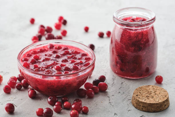 istock Cranberry jam in a glass bowl on a gray background. 1182383695