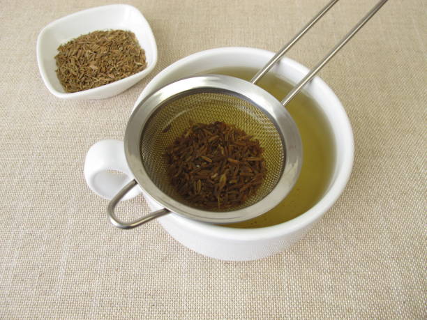 tee aus obstunden samen und caraway früchte im teesieb - caraway seed stock-fotos und bilder