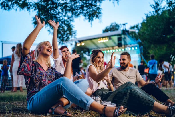 Group of friends on a music festival Group of young Caucasian friends on a music festival sitting in a grass together. popular music concert photos stock pictures, royalty-free photos & images