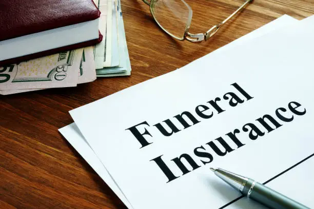 Photo of Funeral insurance agreement, money and glasses.