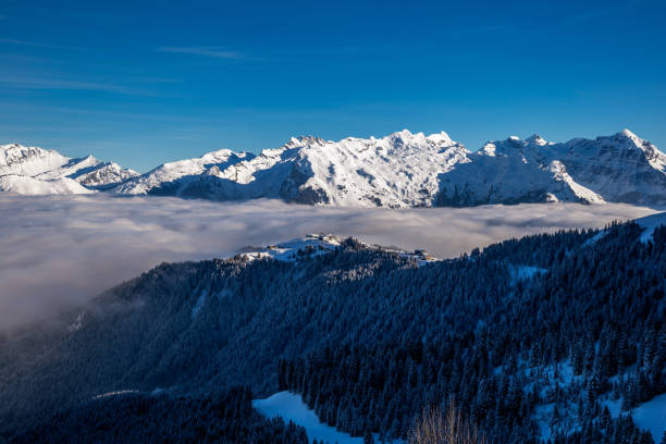 istock Inversion in valley and illuminated mountain peaks 1182386378