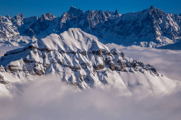istock Panorama of mountains rising from the clouds 1182386418