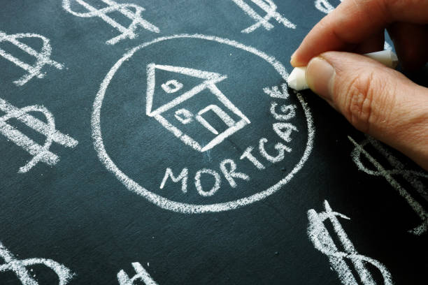 istock Hand is writing word mortgage by chalk. 1182386647