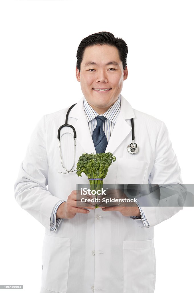 Asian Doctor With Broccoli Young smiling male Asian Doctor holding a stalk of broccoli. 30-39 Years Stock Photo