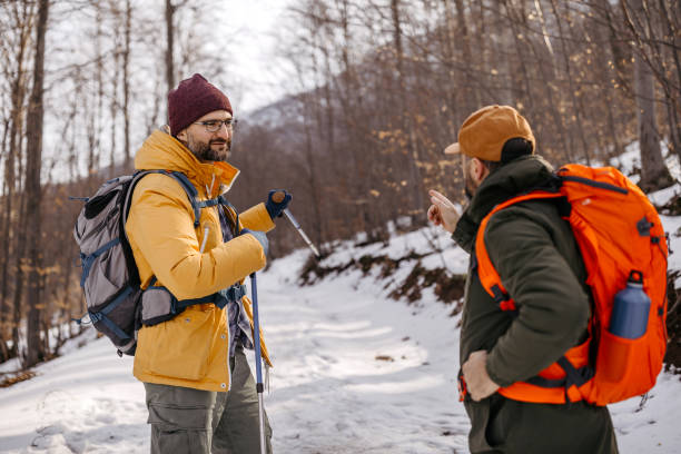 istock Male hikers discussing on snowcapped mountain 1182389133