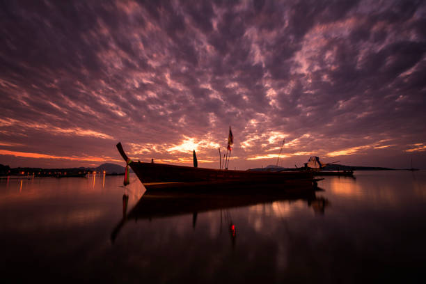 istock Beautiful sunrise with long tail boat on morning time 1182389139