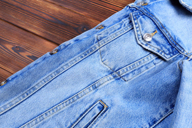 istock blue denim jean jacket  on wooden background - Image 