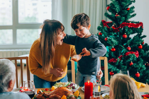 istock Happy mother and her son having fun while holding roasted turkey leg 1182391207