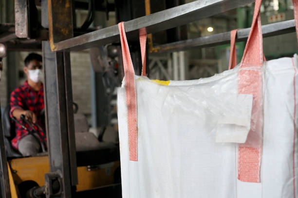 bags with seeds suspended by a crane against the background of the sky, unloading seeds or fertilizers before sowing