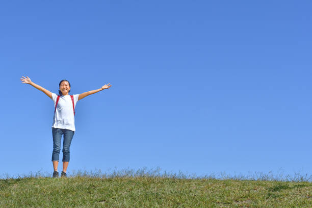 istock Japanese elementary school girl posing in the blue sky 1182395686