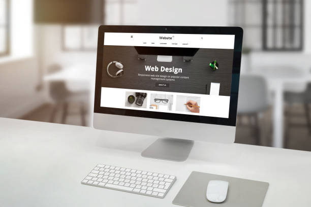 istock Flat web design company site concept on modern computer display in office. Clean desk with keyboard and mouse. Office interior in background. 1182398943