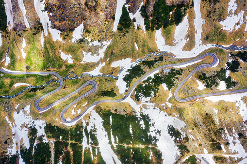 Curvy road in high snow near Pordoi pass, Sella Ronda, Dolomites, Italy.