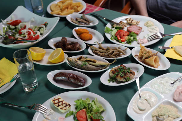 Food of Cyprus: Meze Meal Huge meze meal served commonly in Cyprus. In this photo you can see different fish, sausages, vegetables, etc. on small plates on a table with green table cloth. Delicious huge meal meant for sharing. meze stock pictures, royalty-free photos & images