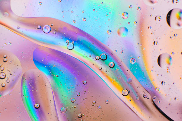 iridescent abstract macro background of moving oil drops - bubble foil imagens e fotografias de stock