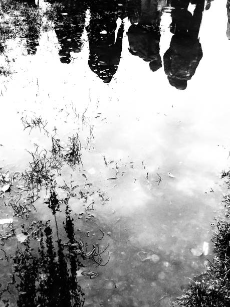 istock Silhouette of people reflex in a puddle in a raining day 1182400914