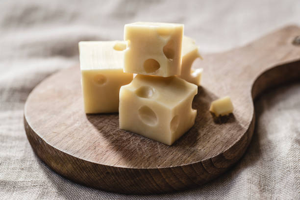 istock Swiss cheese cubes on a wooden board 1182401271