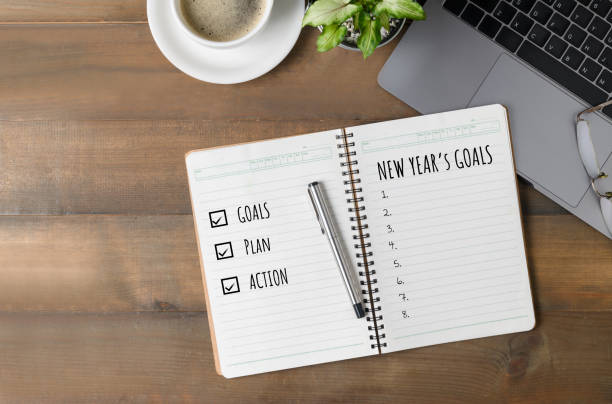 istock Hand man writing New year's goals on note paper 1182401384
