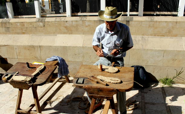 un zapatero o zapatero que muestra cómo hace zapatos y suelas de alpargata hechas con cáñamo y hierba de esparto - elche españa fotografías e imágenes de stock