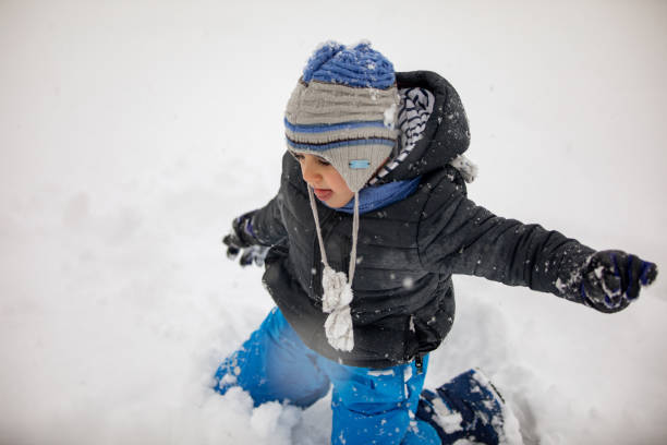 istock Cute little boy playing in snow 1182405295