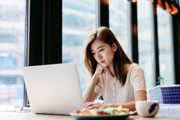 istock Asian woman working laptop at cafe. 1182409430