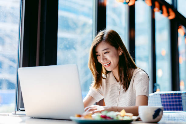 istock Asian woman working laptop at cafe. 1182409438