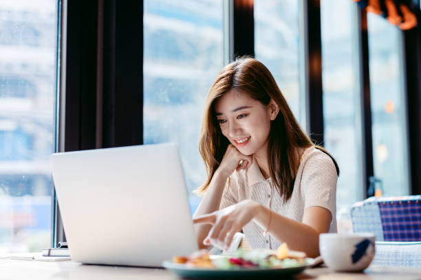 istock Asian woman working laptop at cafe. 1182409439