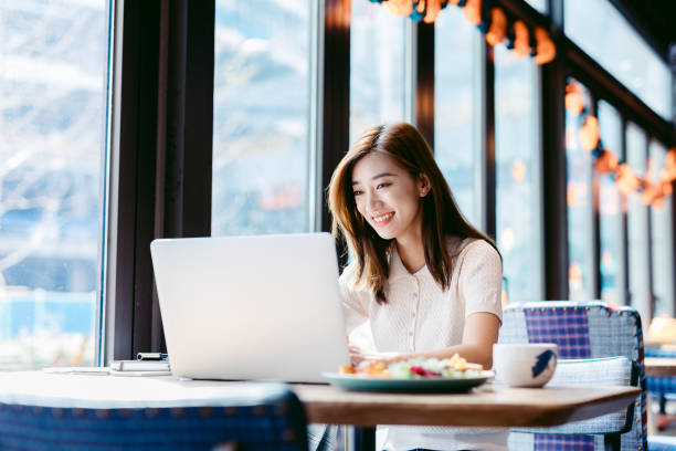 ordinateur portatif de travail de femme asiatique au café. - korean culture photos et images de collection