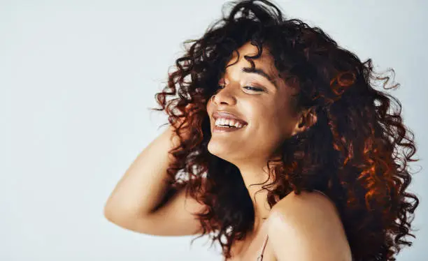 Cropped shot of an attractive young woman feeling playful while posing against a gray background in the studio alone