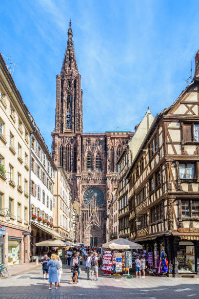 Notre-Dame de Strasbourg cathedral and half-timbered townhouses in Strasbourg, France. Strasbourg, France - September 14, 2019: Facade of Notre-Dame de Strasbourg cathedral seen in the continuation of the busy Merciere street lined with half-timbered townhouses in the historic center. notre dame de strasbourg stock pictures, royalty-free photos & images