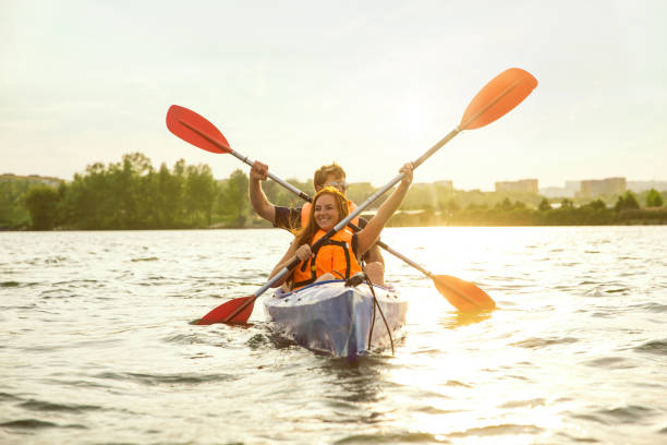 istock Happy couple kayaking on river with sunset on the background 1182411746
