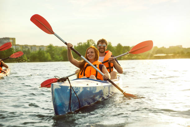 istock Happy couple kayaking on river with sunset on the background 1182411751
