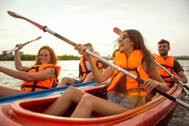 istock Happy friends kayaking on river with sunset on the background 1182411822