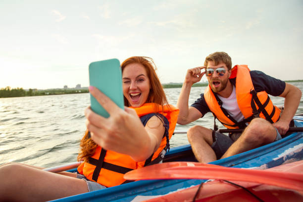 istock Happy couple kayaking on river with sunset on the background 1182411993