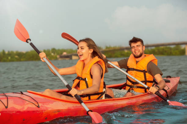 istock Happy couple kayaking on river with sunset on the background 1182412009