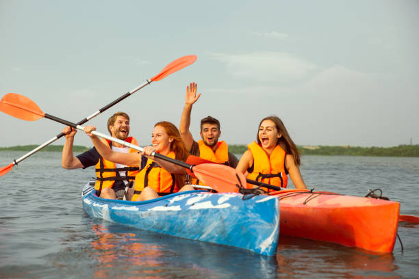 istock Happy friends kayaking on river with sunset on the background 1182412016