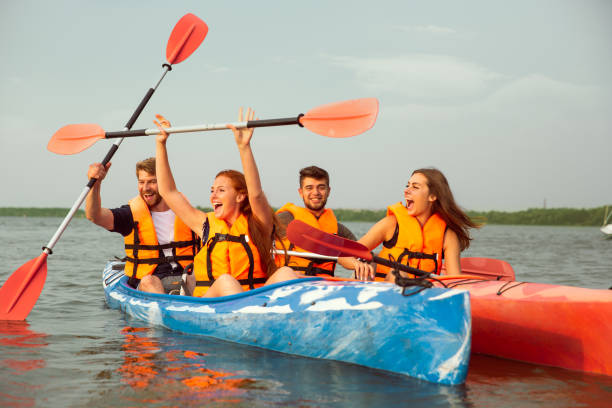 istock Happy friends kayaking on river with sunset on the background 1182412017