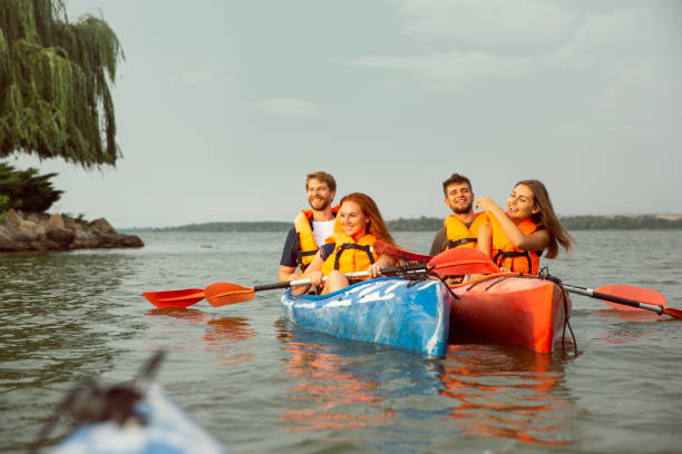 istock Happy friends kayaking on river with sunset on the background 1182412021