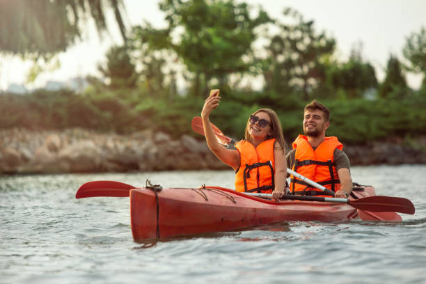 istock Happy couple kayaking on river with sunset on the background 1182412030