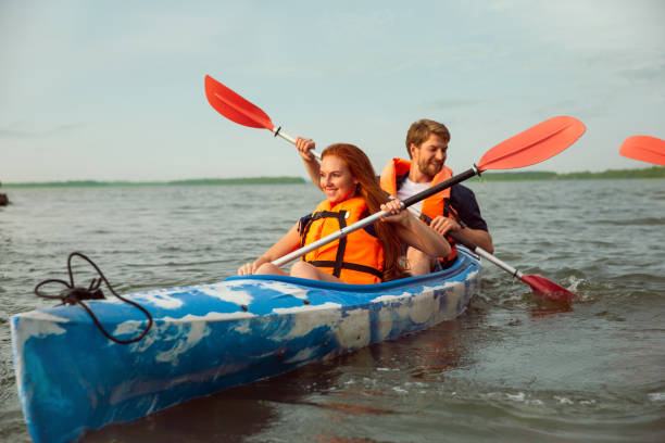 istock Happy couple kayaking on river with sunset on the background 1182412033