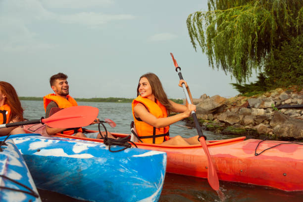 istock Happy friends kayaking on river with sunset on the background 1182412041