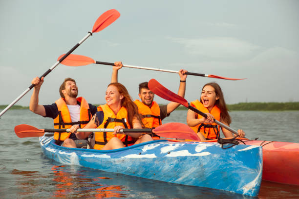 istock Happy friends kayaking on river with sunset on the background 1182412042