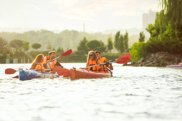 istock Happy friends kayaking on river with sunset on the background 1182412045
