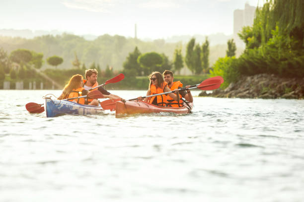 istock Happy friends kayaking on river with sunset on the background 1182412047