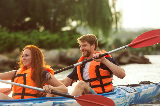 istock Happy couple kayaking on river with sunset on the background 1182412053